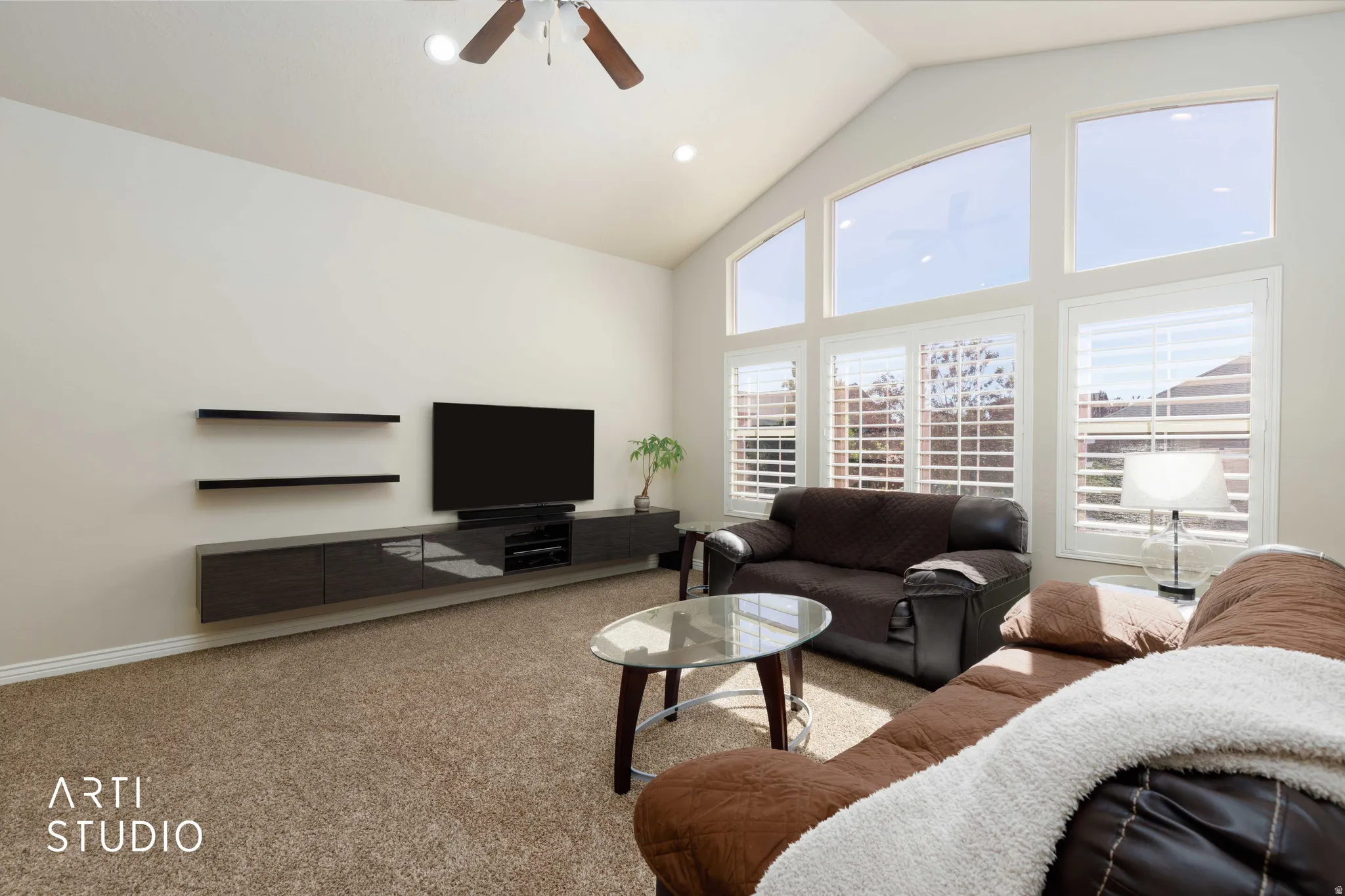 Open-concept living space featuring a vaulted ceiling and a ceiling fan