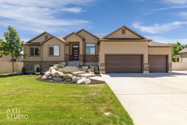 Stucco exterior with stone accents and a multi-level concrete walkway