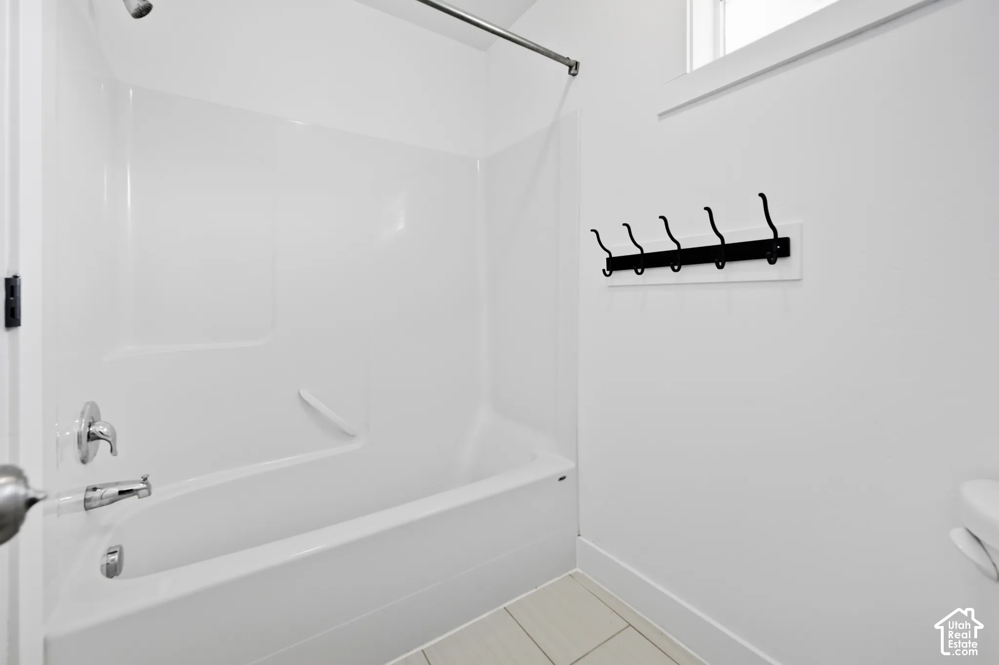 White tub and shower combination with chrome fixtures