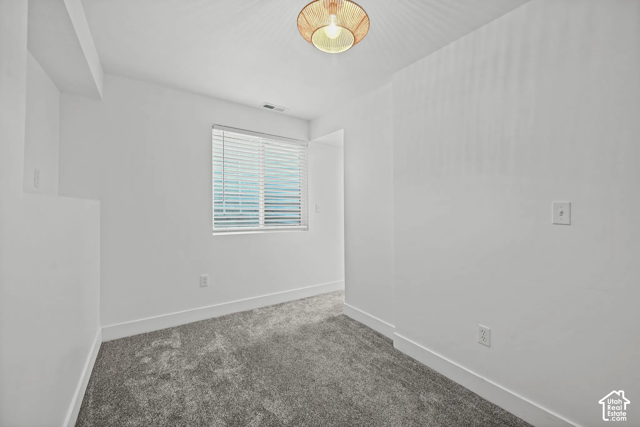 Neutral white walls complement the gray carpeting