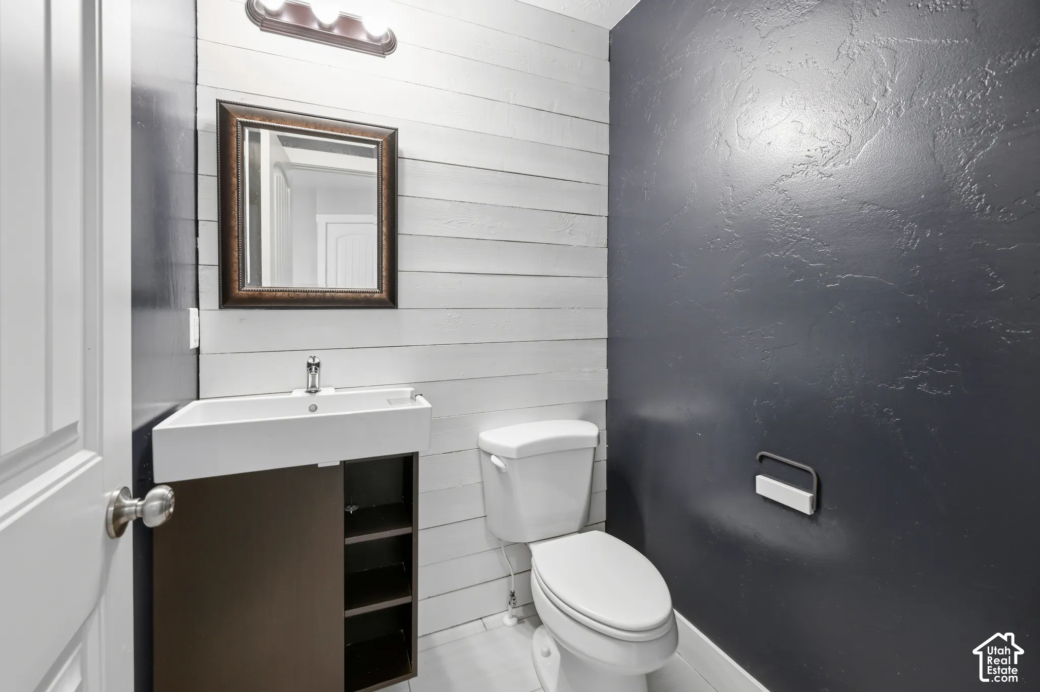 Bathroom featuring a modern floating vanity with an integrated sink, a dark wood-finish cabinet, and a framed mirror