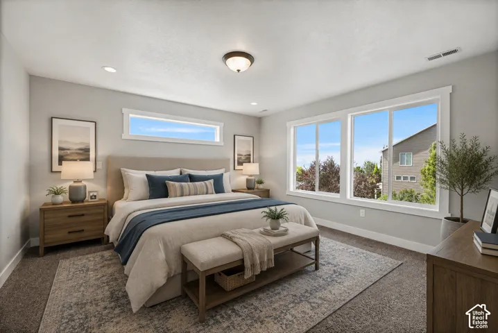 Carpeted sleeping area featuring a textured area rug, recessed lighting, and a neutral color palette