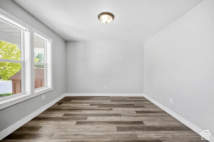 Room featuring wood-finish flooring, light gray walls, white trim, and a semi-flush mount ceiling light fixture
