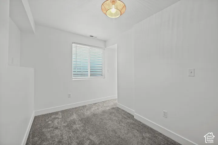 Neutral white walls complement the gray carpeting