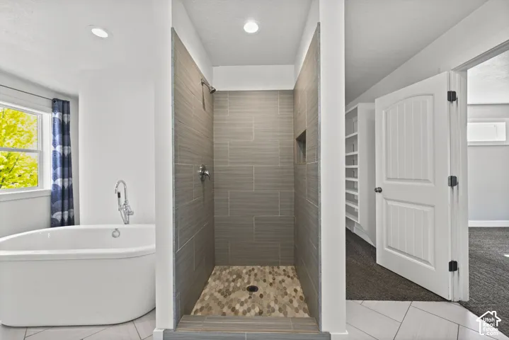 Contemporary bathroom featuring a freestanding soaking tub with a floor-mounted faucet, a walk-in shower with horizontal tile walls, a built-in shower niche, and a mosaic tile shower floor