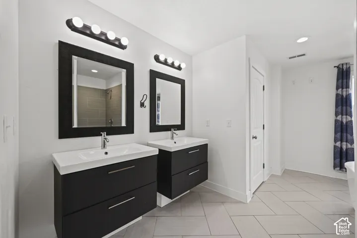 Dual floating vanities with integrated sinks, contemporary wall-mounted light fixtures, and coordinating framed mirrors