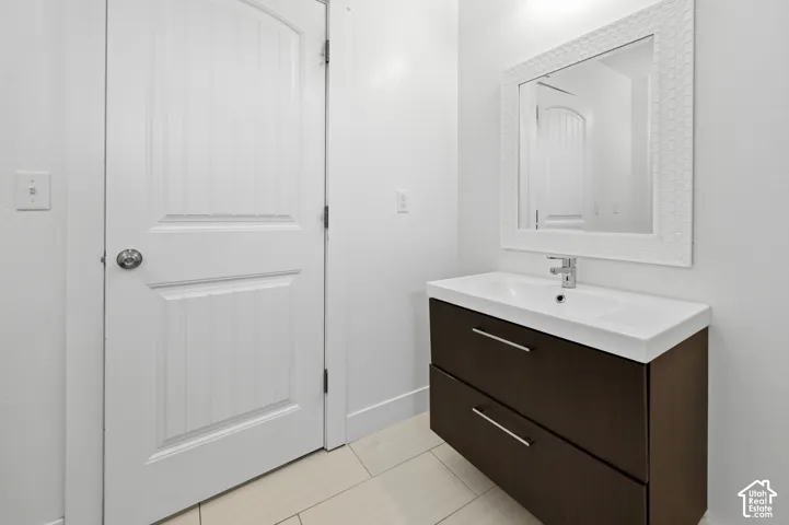 Floating vanity with integrated sink, chrome faucet, and dark wood-finish drawers
