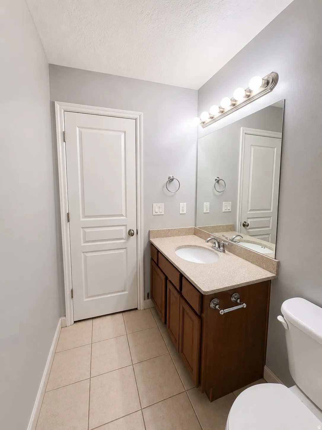 Bathroom vanity featuring an integrated sink, polished chrome faucet, and ample storage cabinetry