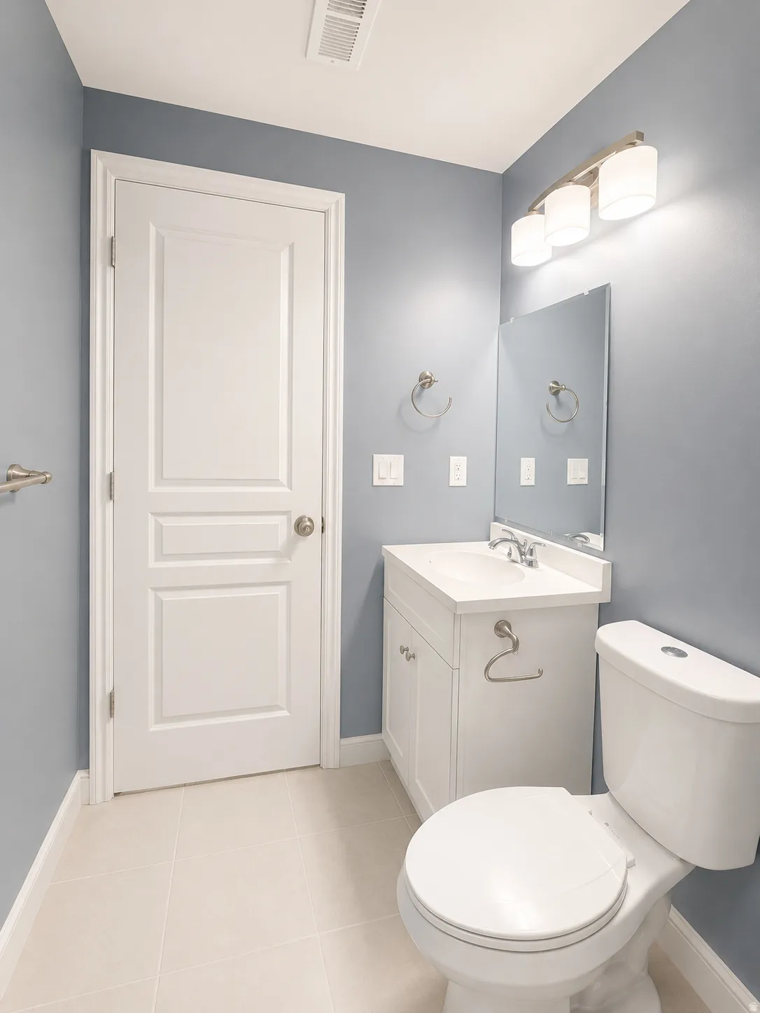 Bathroom featuring a white vanity with integrated sink, chrome faucet, and rectangular mirror