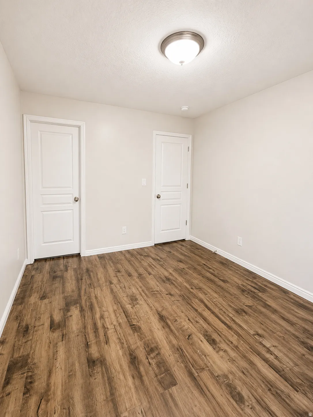 Neutral wall tones complement the wood-finish flooring