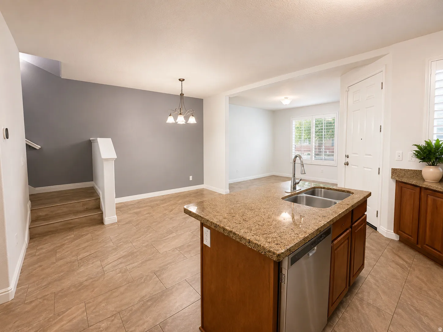 Kitchen island with a double basin stainless steel sink, gooseneck faucet, and integrated dishwasher