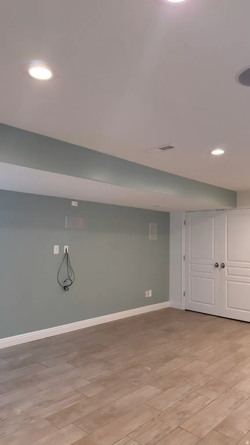 Recessed lighting illuminates wood-finish tile flooring