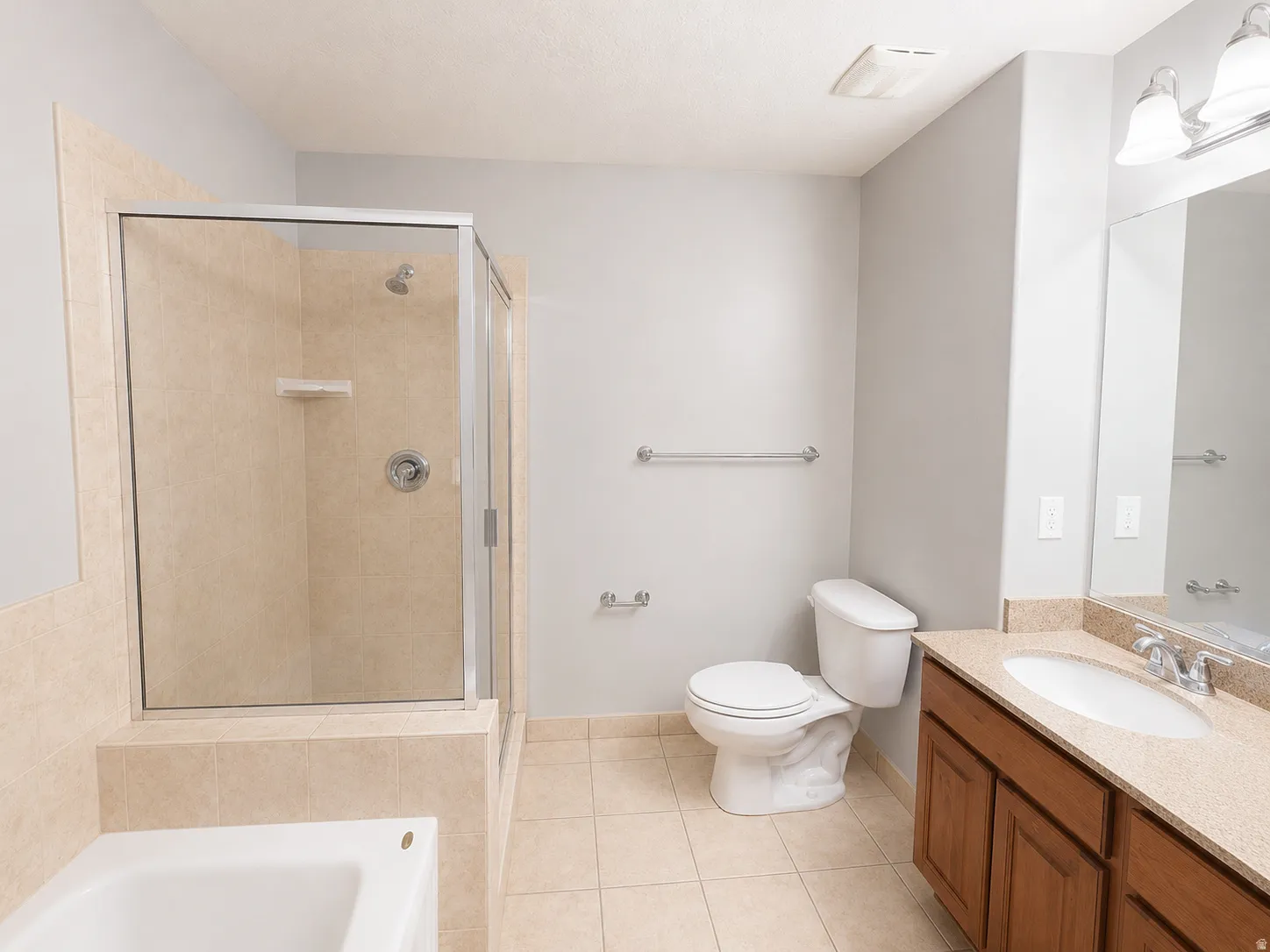 Bathroom featuring a walk-in shower with glass enclosure, a built-in bathtub, and an integrated vanity with a single basin