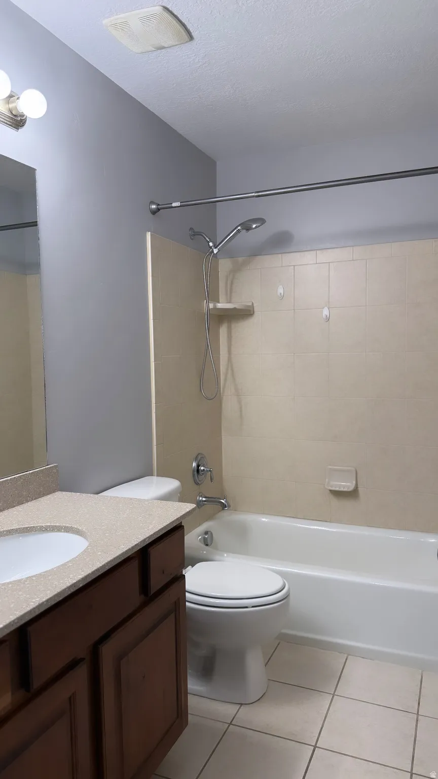 Bathroom featuring a dark wood-finish vanity with a light speckled countertop, an integrated sink, and brushed nickel hardware