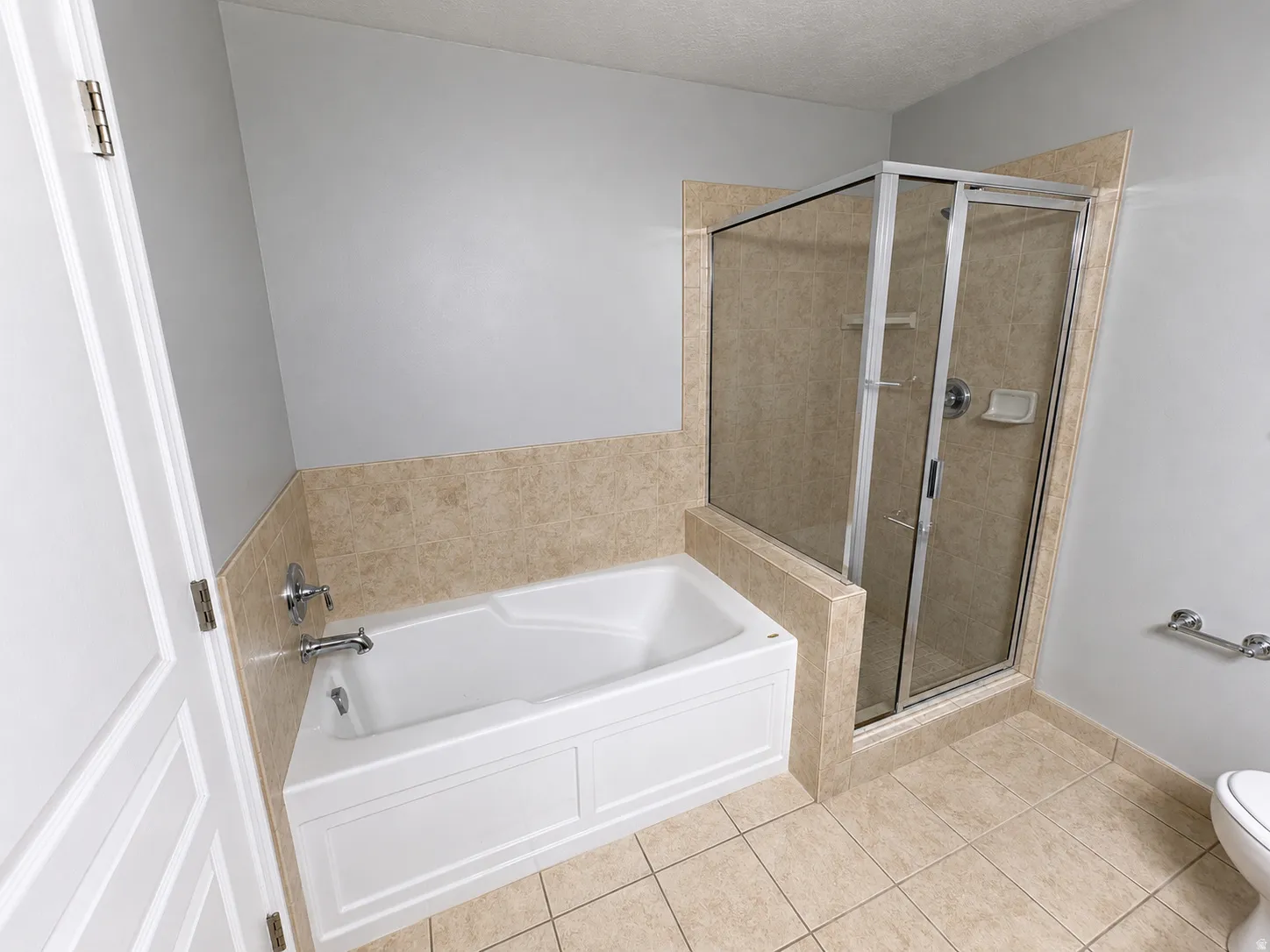 Bathroom featuring a combination tub and shower with glass enclosure