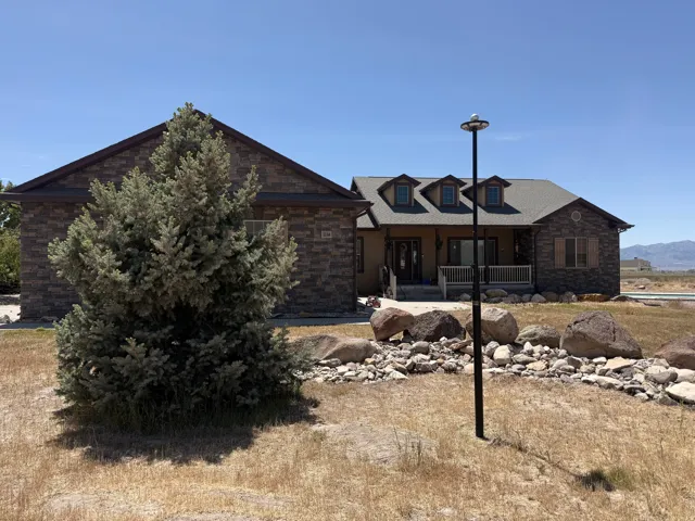Stone veneer facade with a covered porch and dormer windows