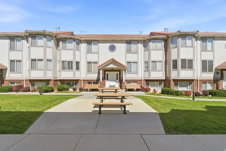 Multi-story building featuring a stucco exterior with brick accents and a tile roof
