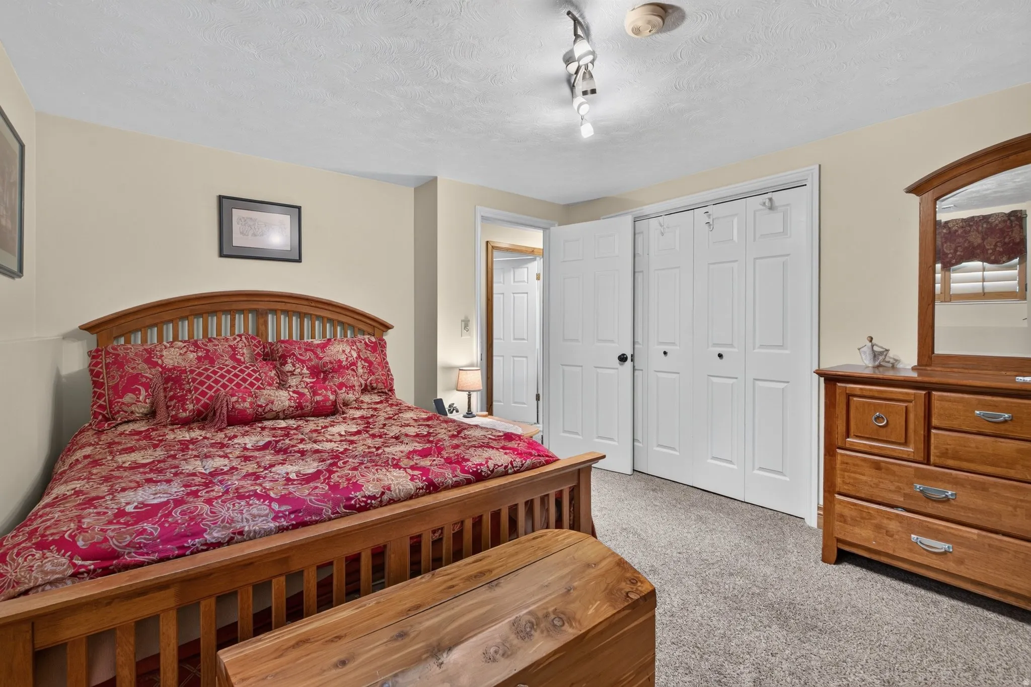 Carpeted room with neutral wall tones and a textured ceiling