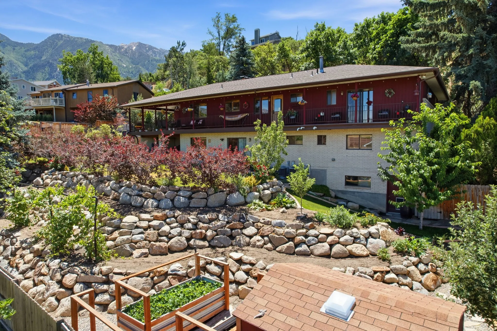 Terraced landscaping featuring natural stone retaining walls and mature shrubbery