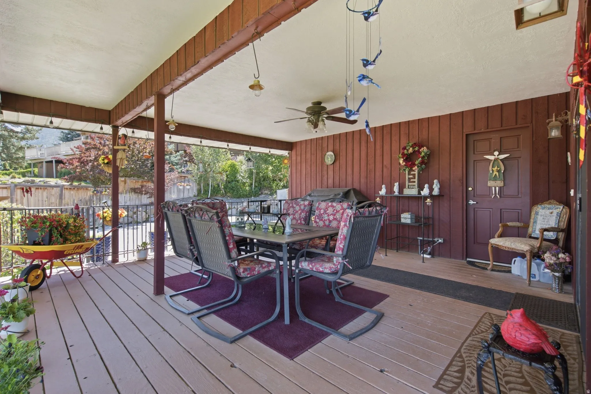Expansive covered deck featuring a wood-finish floor, vertical wood paneling, and an exposed beam ceiling