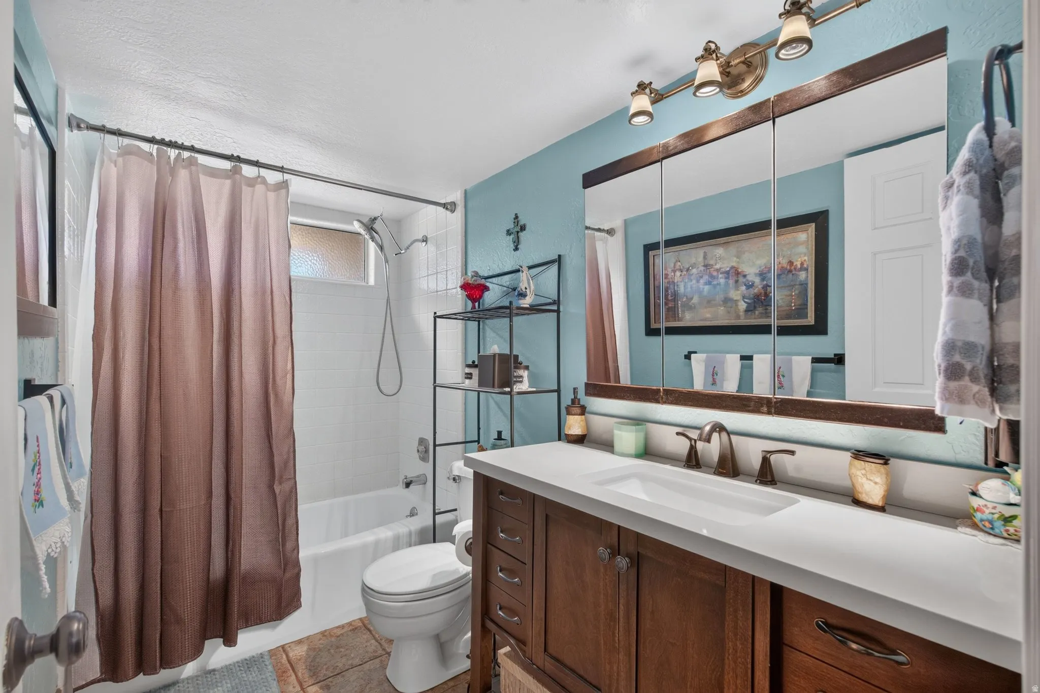 Bathroom featuring a wood vanity with a white countertop, an integrated sink, and bronze-finish hardware