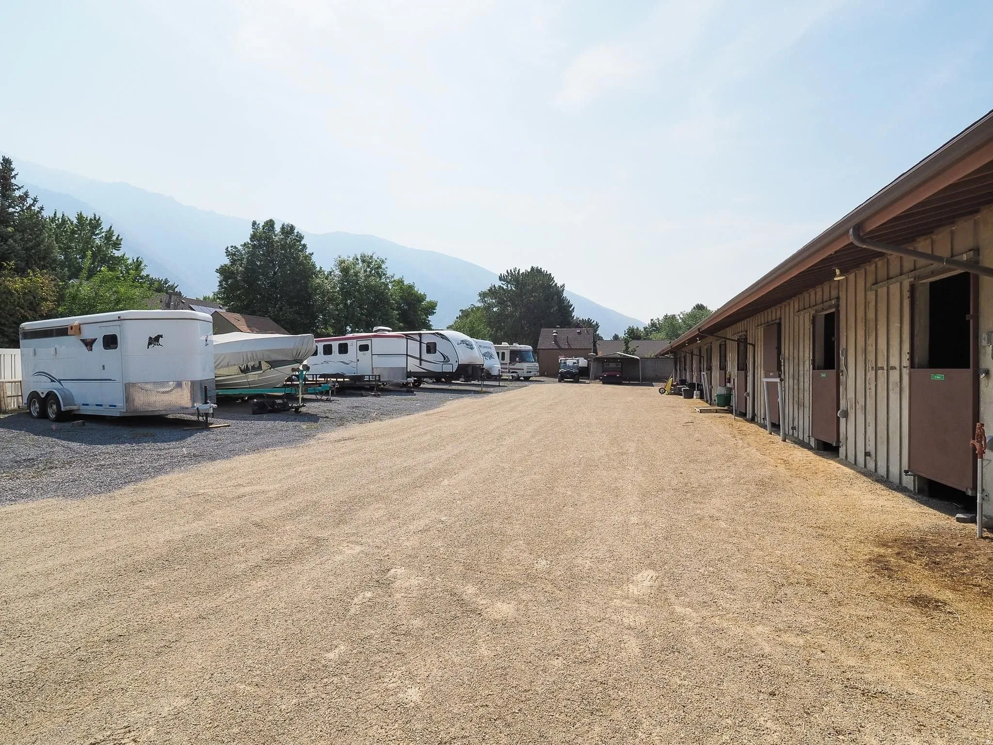 Property includes a multi-stall barn structure with individual stalls featuring Dutch doors
