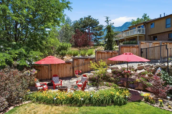 Terraced backyard with a rock garden, mature landscaping, and a mountain backdrop