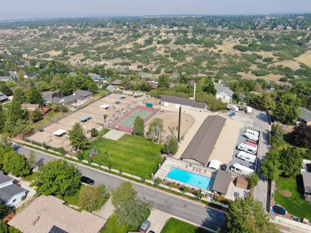 Expansive property featuring an outdoor swimming pool, tennis court, and multiple fenced equestrian paddocks