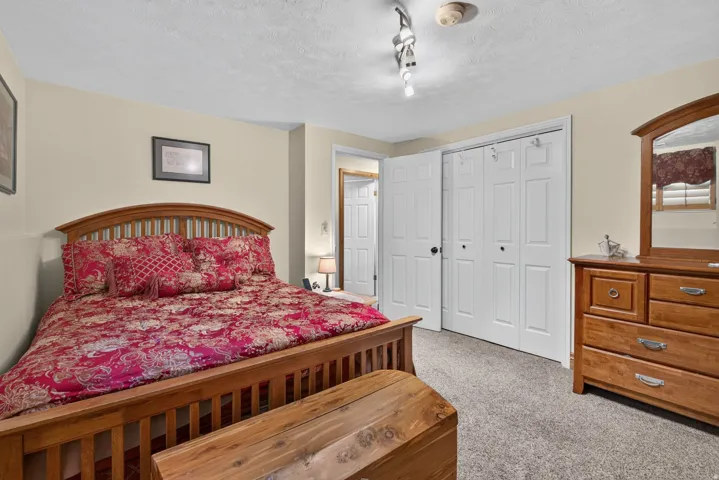 Carpeted room with neutral wall tones and a textured ceiling