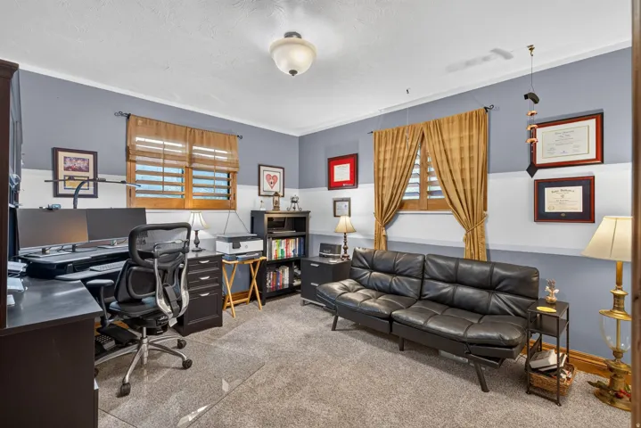 Carpeted interior room with two-toned walls featuring a light gray and white dado