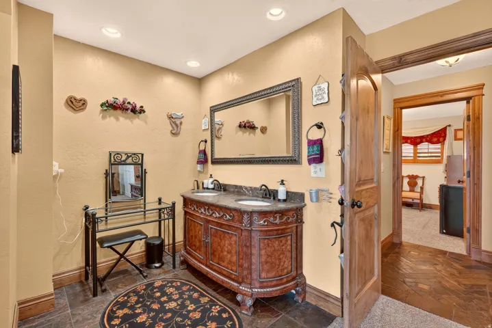 Double vanity with an ornate wood-finish cabinet and stone countertop