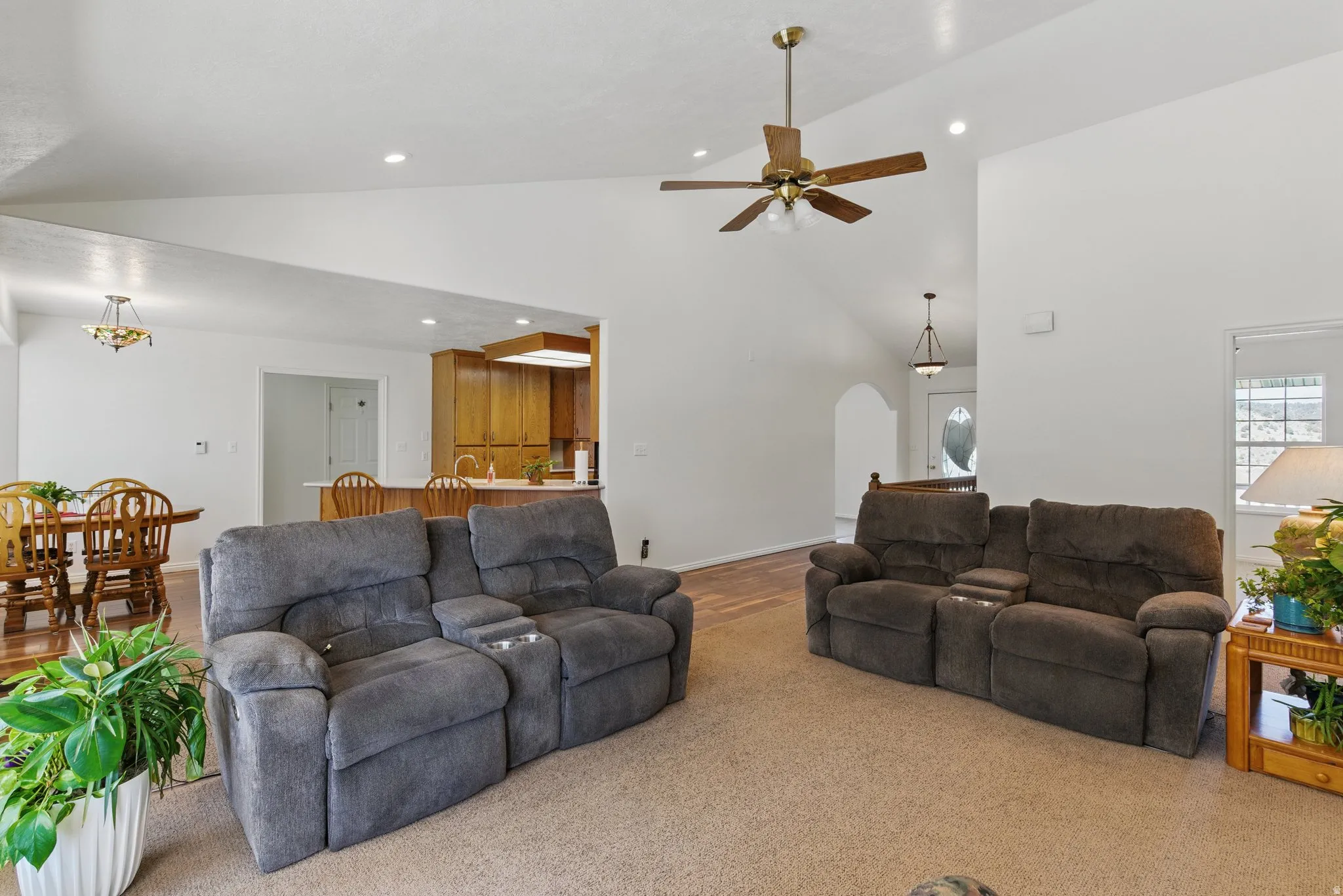 Spacious interior featuring a vaulted ceiling with recessed lighting and a ceiling fan