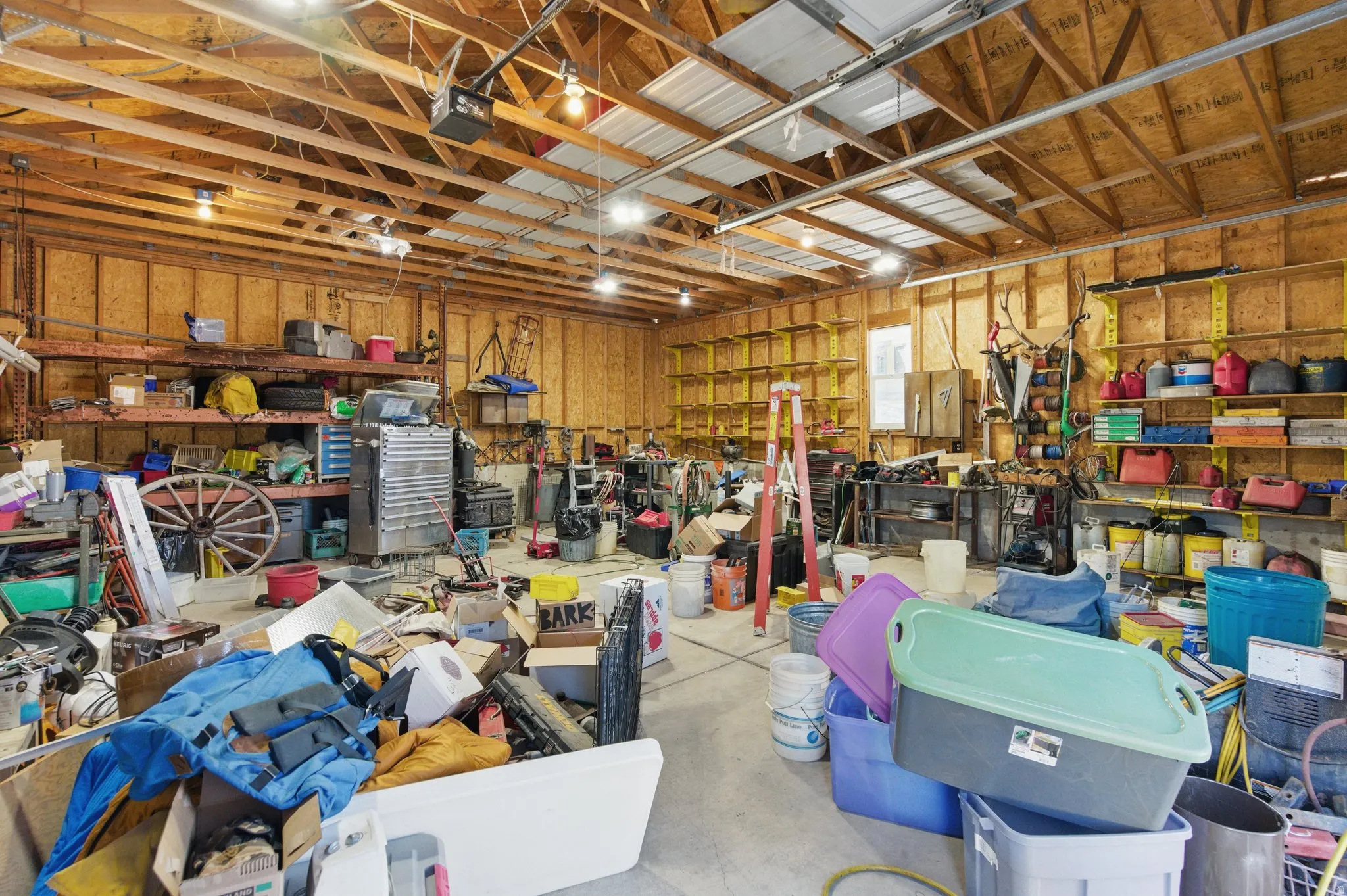 Spacious garage with exposed wood beam ceiling and concrete flooring