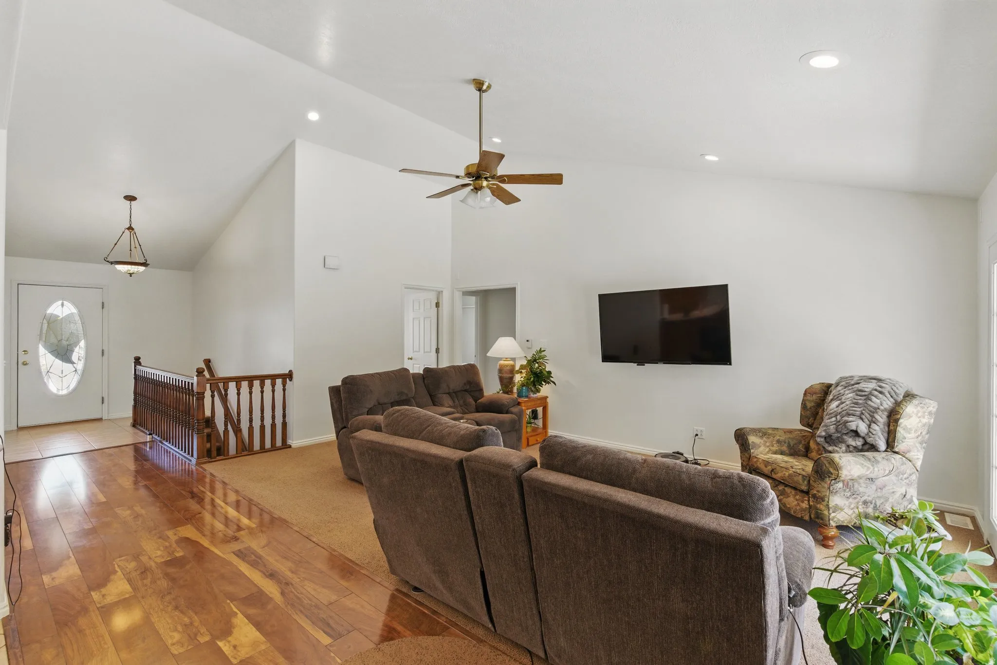 Entryway with wood-finish flooring transitioning to carpeted living area