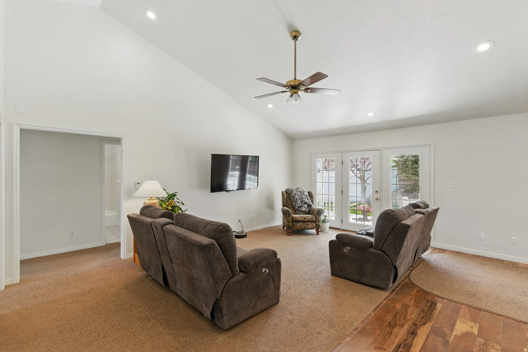 Living area featuring a vaulted ceiling with a ceiling fan, recessed lighting, and a wall-mounted television