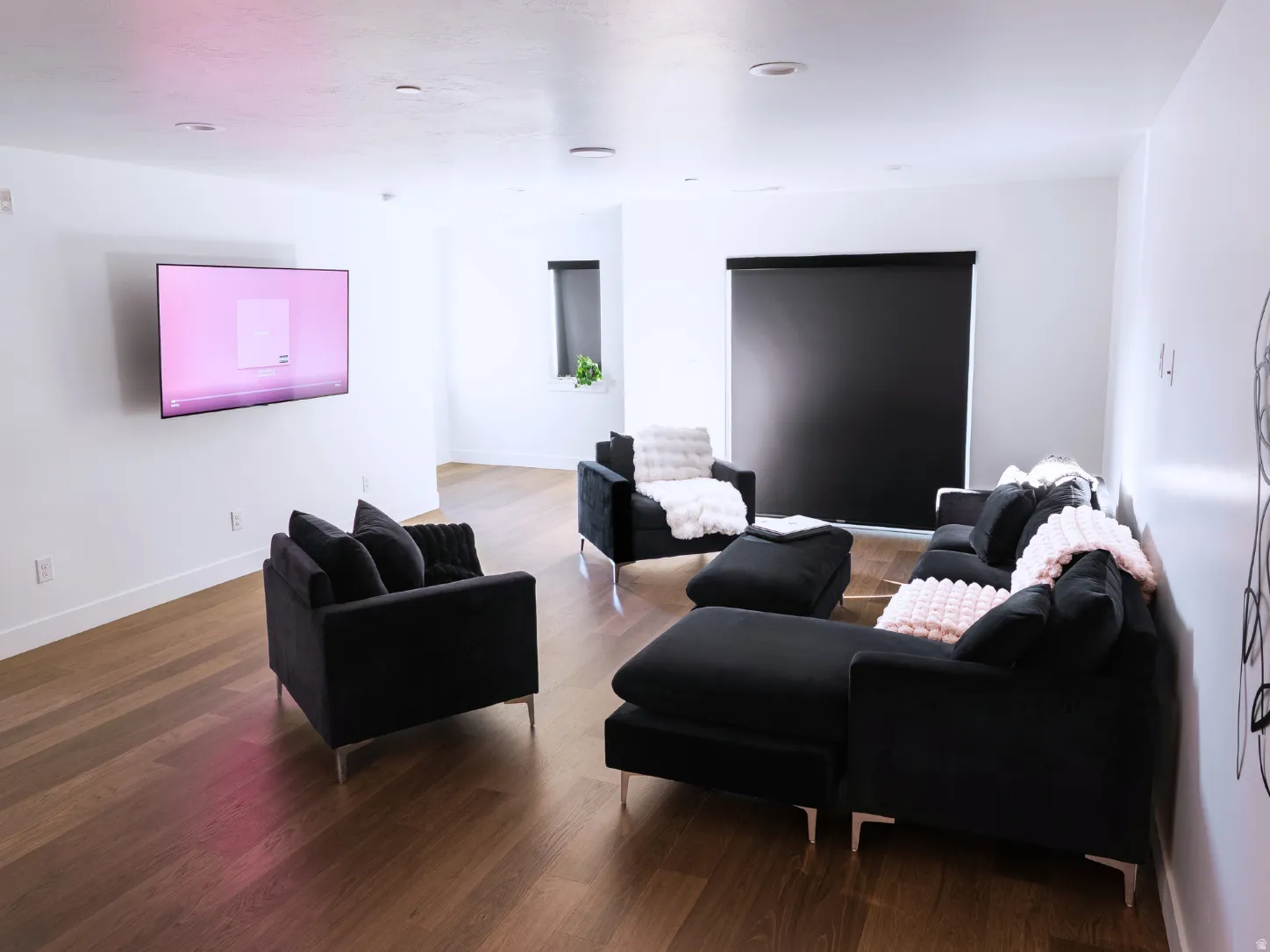 Spacious living area featuring wood-finish flooring and recessed lighting