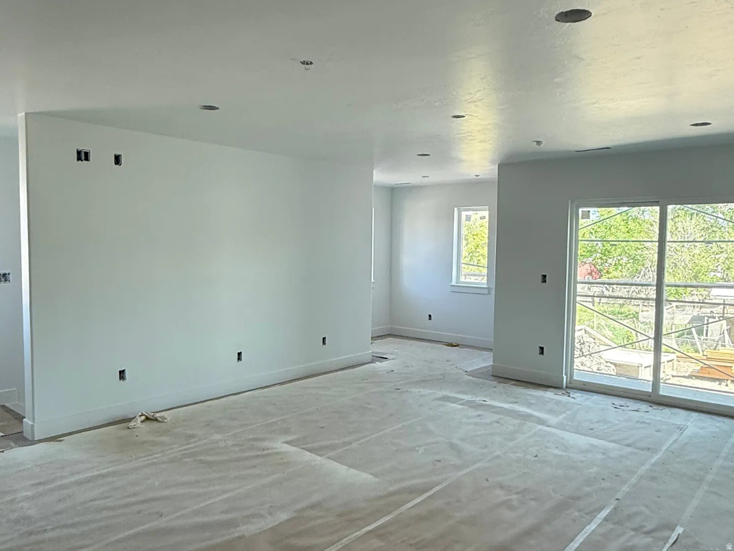 Recessed lighting, white walls, multiple windows, sliding glass door, white trim