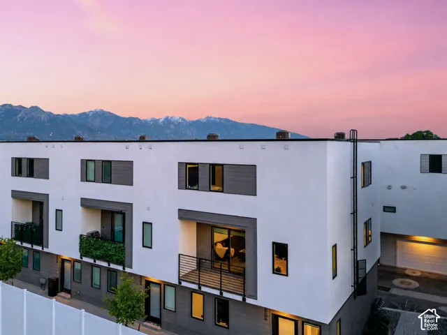 Modern multi-story facade featuring white stucco and gray horizontal siding accents
