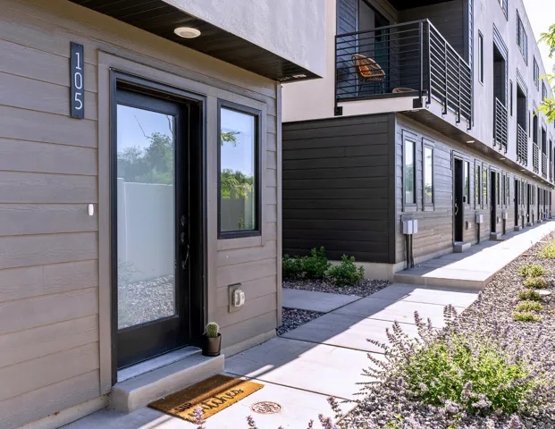 Modern exterior with horizontal siding, a glass-paneled entry door, and dark-framed windows