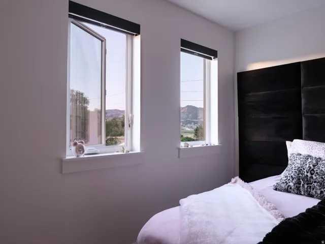 Dual casement windows with white trim and sills