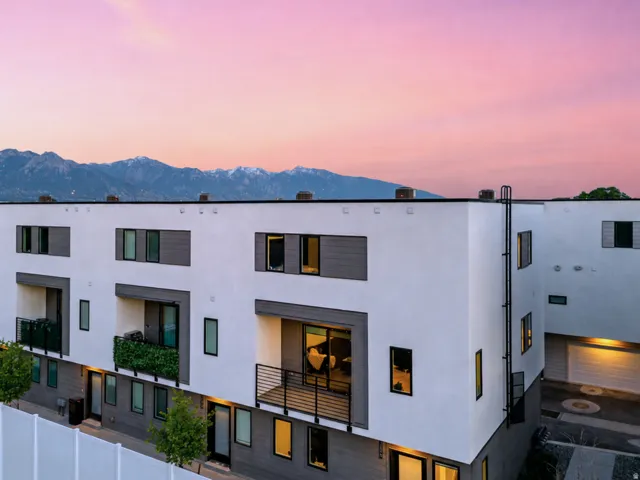 Modern multi-story facade featuring white stucco and gray horizontal siding accents