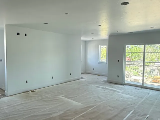 Recessed lighting, white walls, multiple windows, sliding glass door, white trim