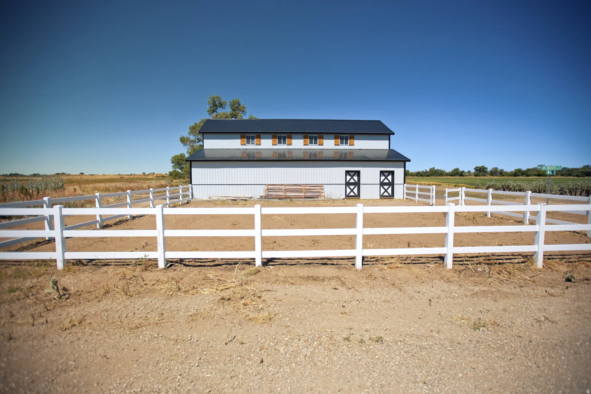 Two-story barn with white siding and dark roof
