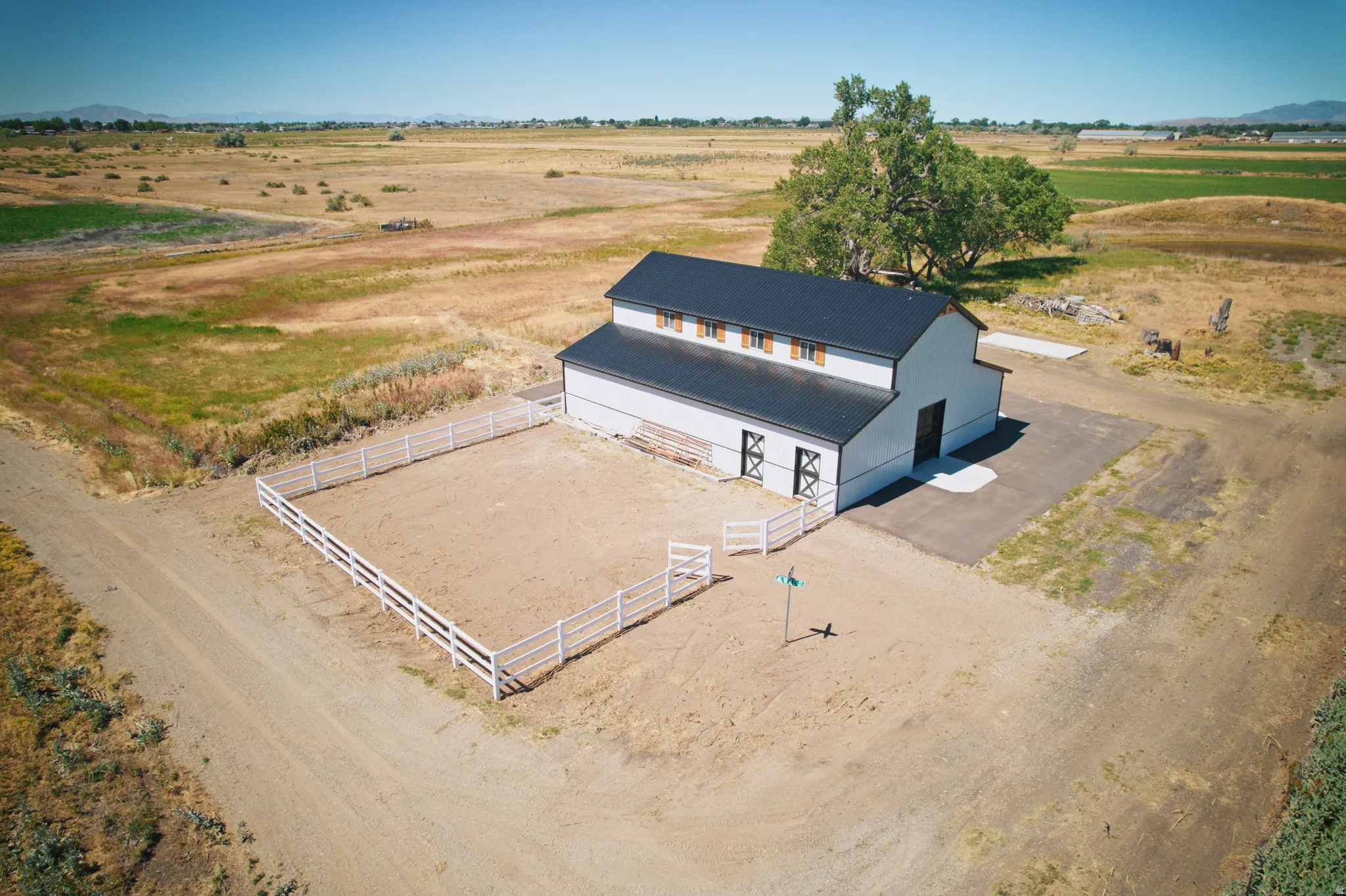 Modern barn structure with a dark roof and white siding