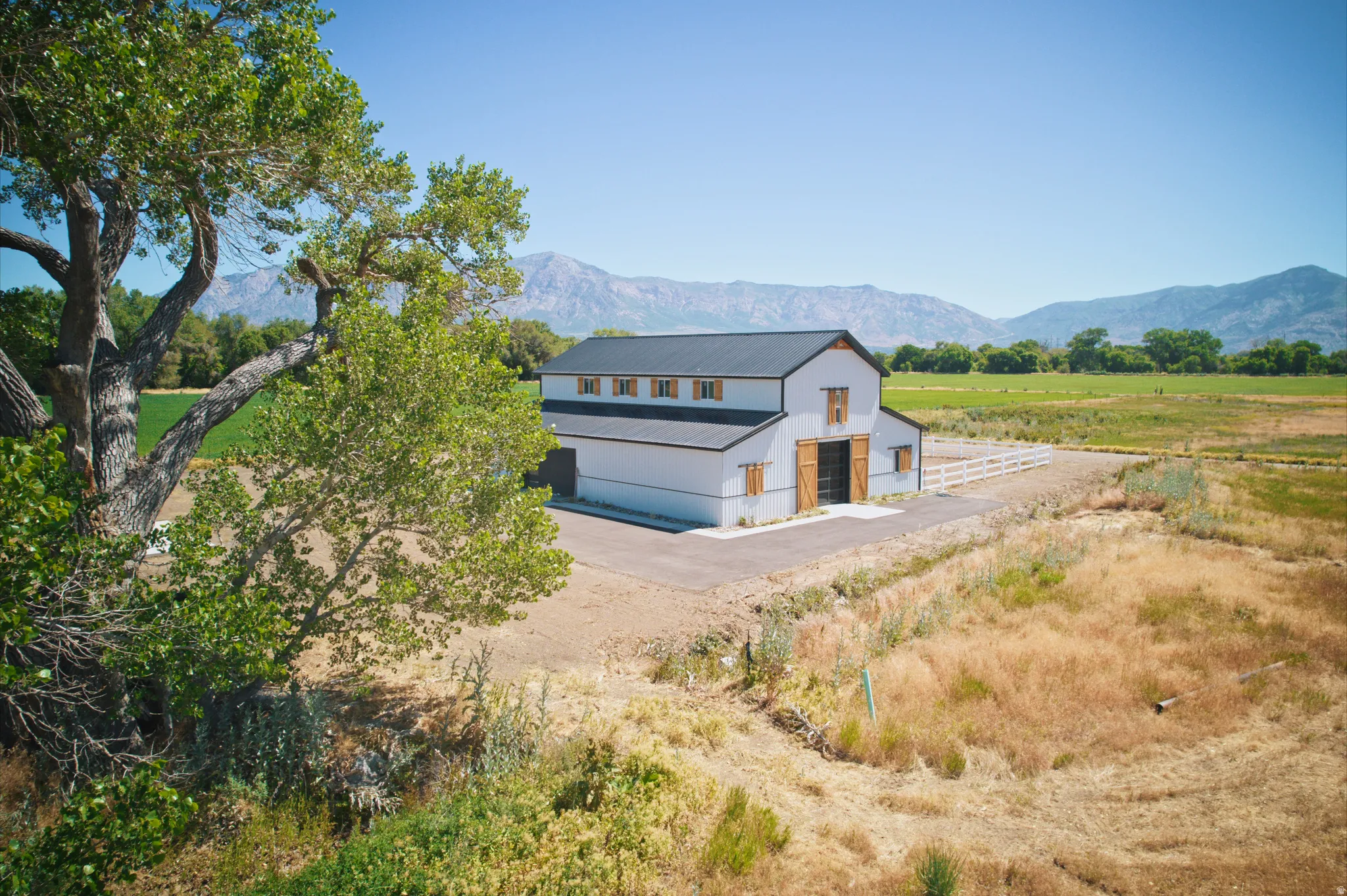 Modern barn structure with a dark metal roof and white siding