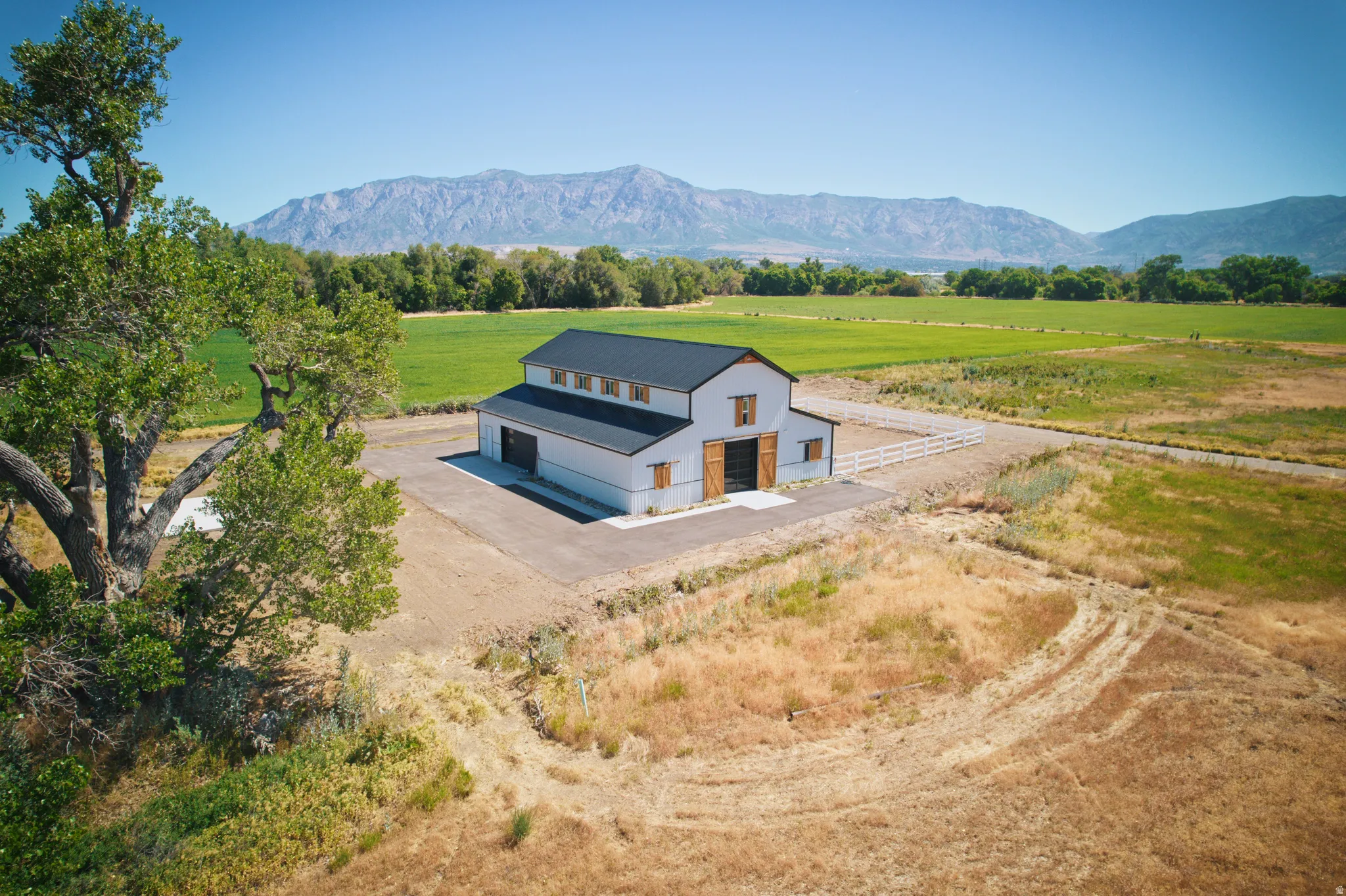 Modern barn-style structure featuring light gray siding and a dark roof