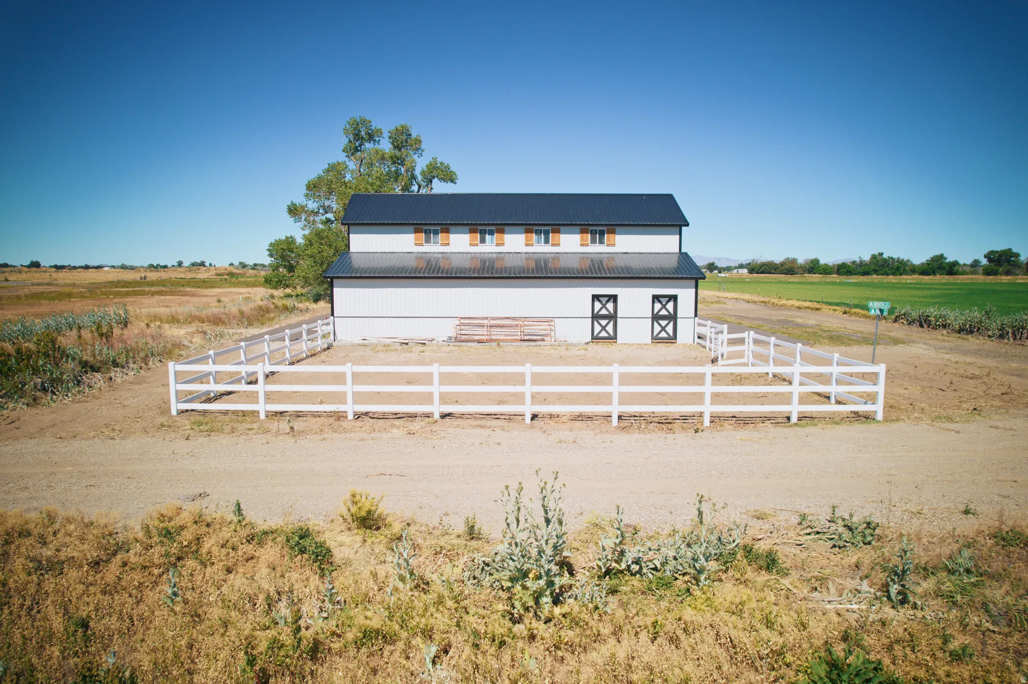 Two-story barn structure featuring a dark metal roof and white siding