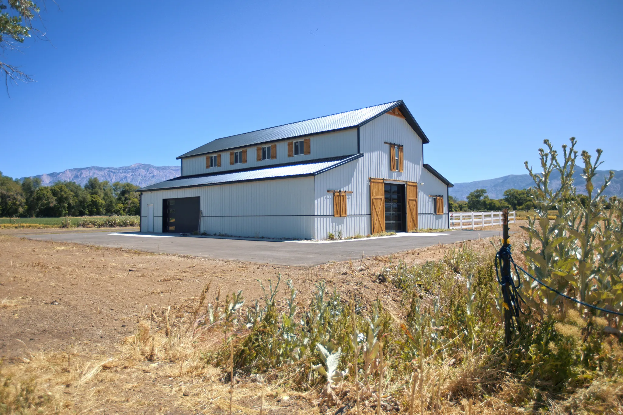 Two-story barn structure with corrugated metal siding and a dark metal roof