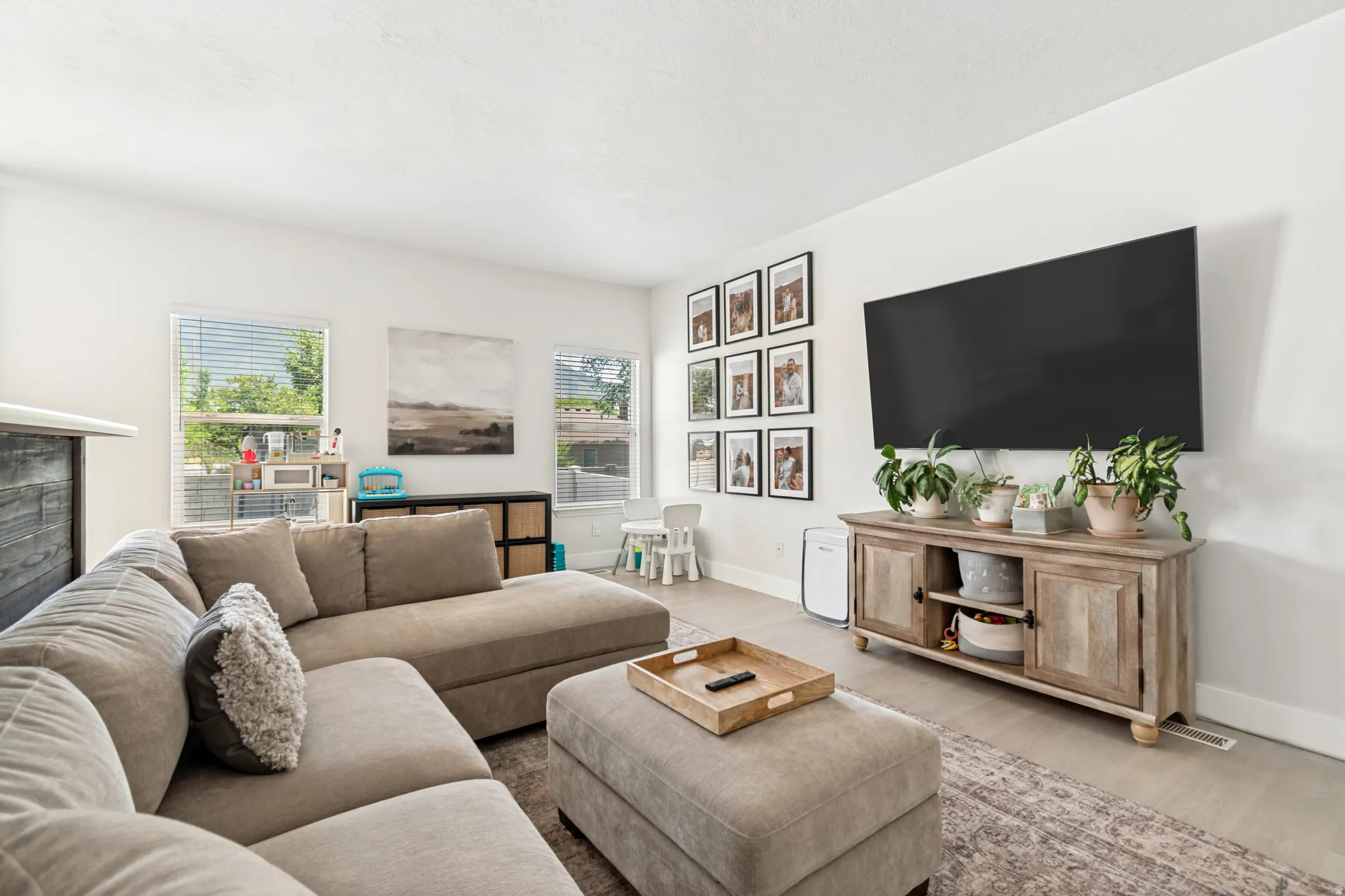 Open concept living area featuring light-colored walls and wood-finish flooring