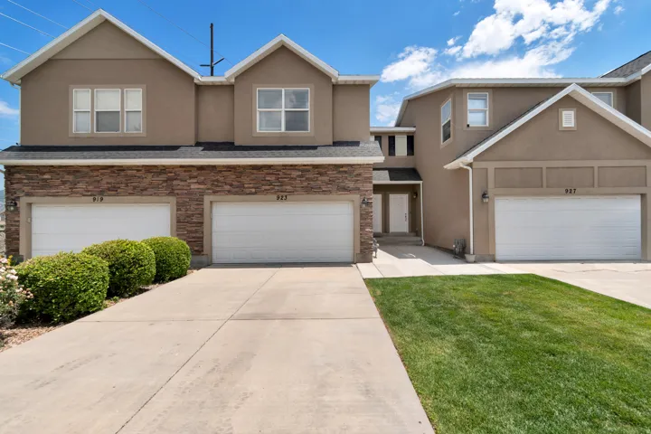 Townhouse-style exterior with stucco siding and stone veneer accents